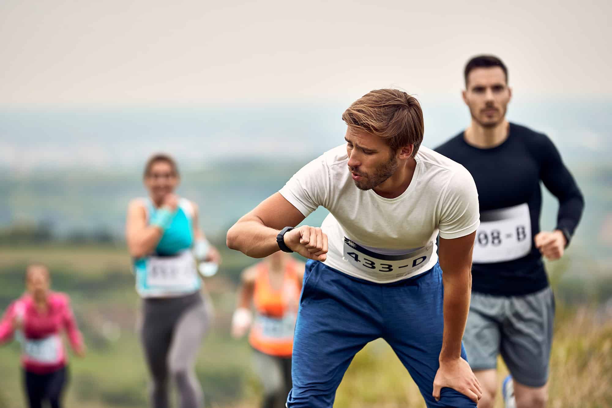 man at run race looking at smartwatch