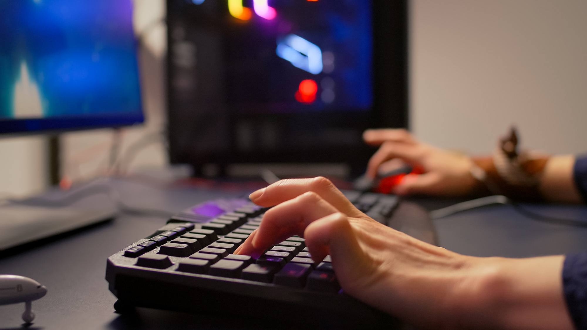 hands on keyboard with PC in the background